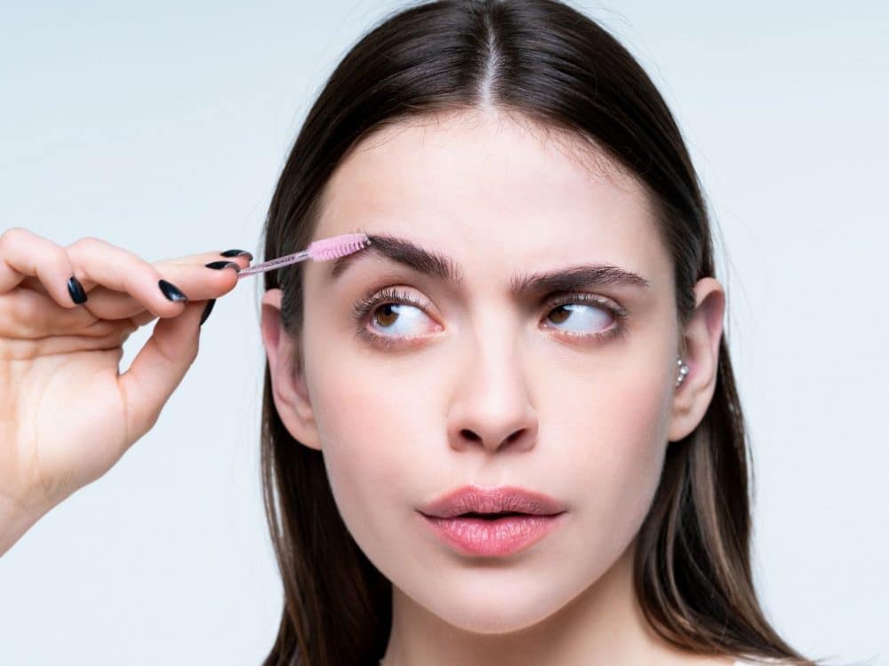 woman combs her eyebrows